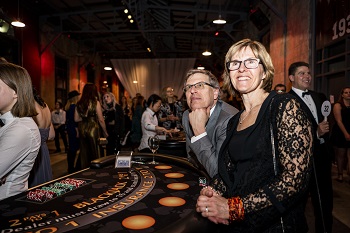 Two smiling guests standing at the Blackjack table